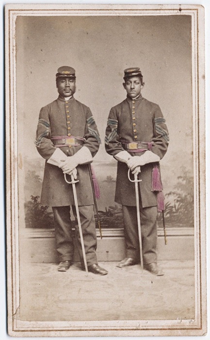 Two Civil War soldiers from CT's Colored regiment standing up straight with their army swords at their waist.